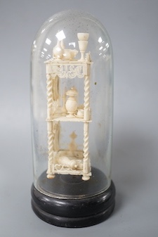 A Victorian ivory model of objects on a whatnot, under a glass dome 16cm